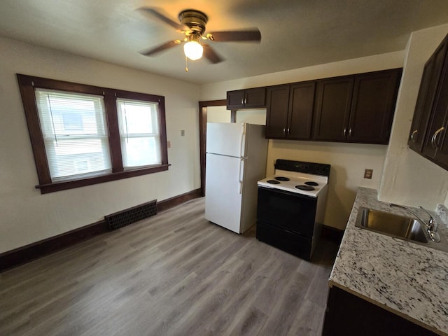 kitchen with light wood-style flooring, a sink, visible vents, freestanding refrigerator, and electric range oven