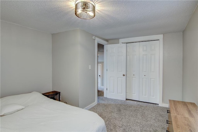 bedroom featuring a textured ceiling, a closet, carpet flooring, and baseboards