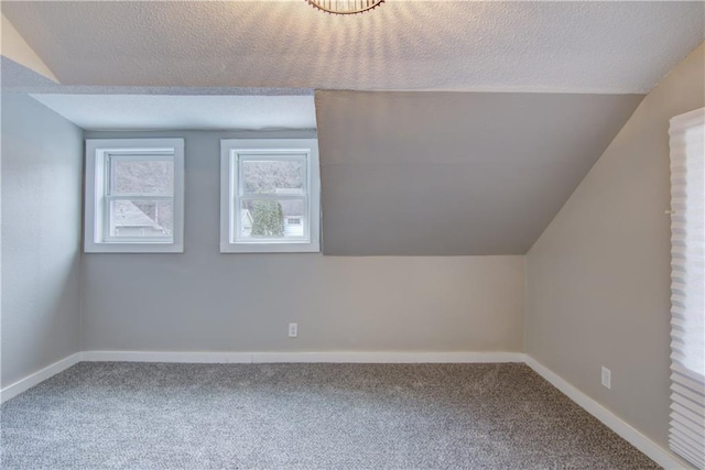 bonus room with a textured ceiling, baseboards, and carpet flooring