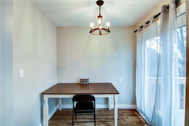 dining room with an inviting chandelier, baseboards, and wood finished floors