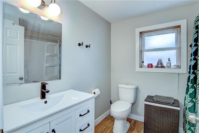 full bath featuring curtained shower, toilet, vanity, wood finished floors, and baseboards