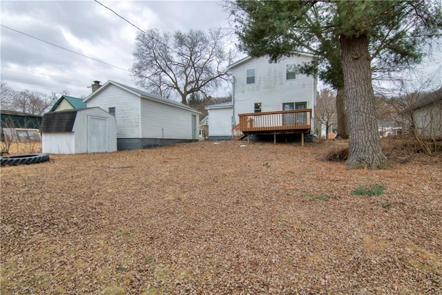 rear view of house featuring a storage shed, a deck, and an outbuilding