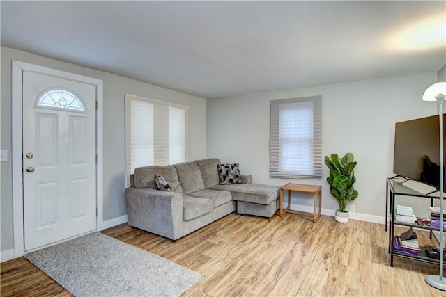 living area featuring baseboards and light wood-style floors