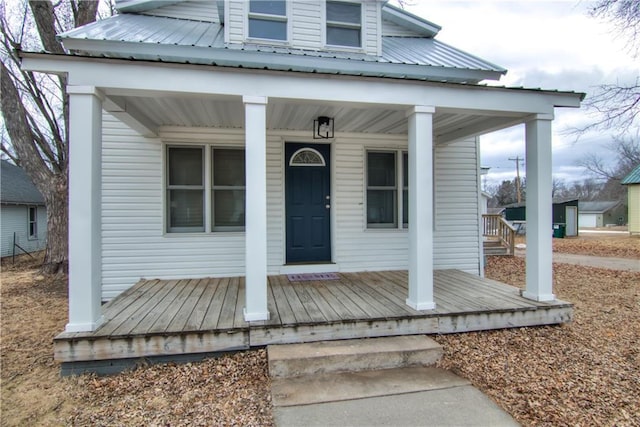 doorway to property with a porch and metal roof