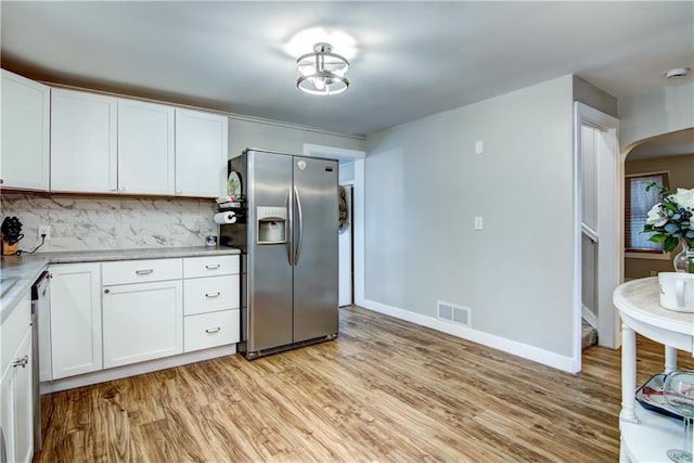 kitchen featuring dishwashing machine, light wood-style flooring, visible vents, stainless steel refrigerator with ice dispenser, and backsplash