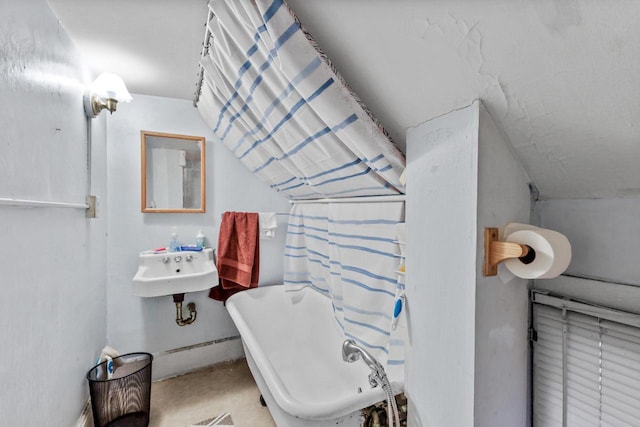 bathroom featuring vaulted ceiling, curtained shower, a sink, and a bathtub