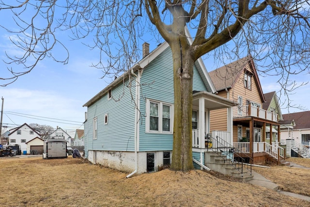 view of property exterior featuring a residential view, a chimney, and a porch