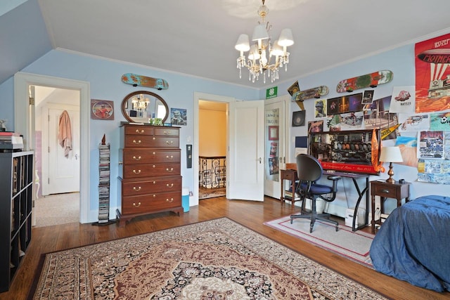 bedroom with crown molding, wood finished floors, and a notable chandelier