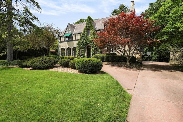 view of front of house featuring driveway, a front yard, and stucco siding