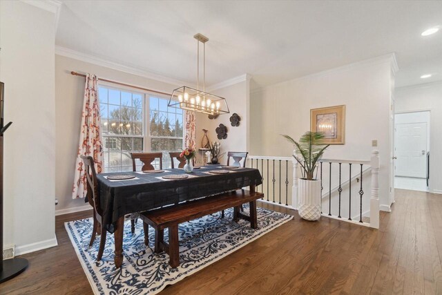 dining room featuring ornamental molding, dark wood-type flooring, a notable chandelier, and baseboards