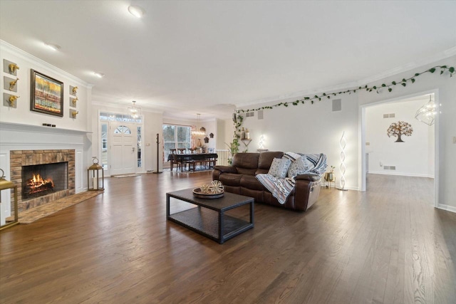 living room with a fireplace with flush hearth, visible vents, baseboards, ornamental molding, and dark wood finished floors