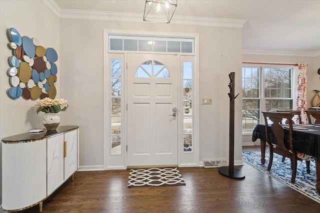 foyer entrance with dark wood-style floors, baseboards, visible vents, and crown molding