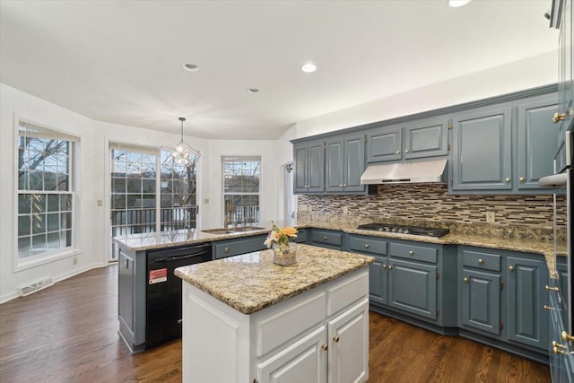 kitchen with under cabinet range hood, a kitchen island, visible vents, black dishwasher, and stainless steel gas stovetop