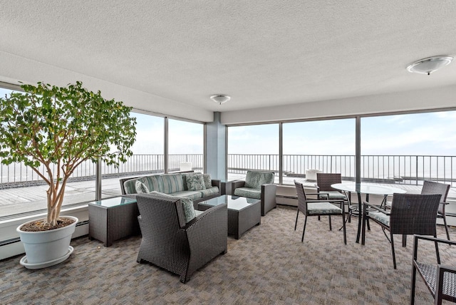 carpeted living room featuring baseboard heating and a textured ceiling