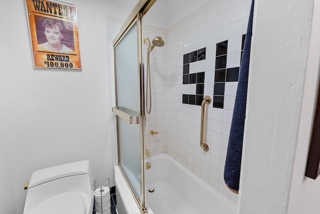 bathroom featuring toilet and bath / shower combo with glass door