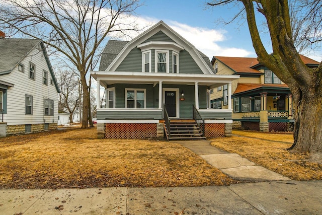 view of front facade with covered porch and a gambrel roof