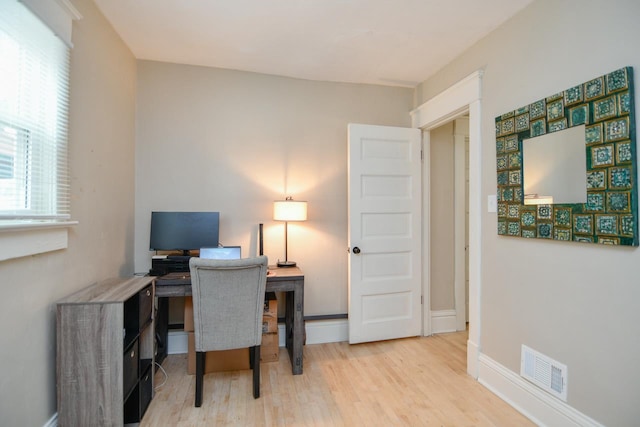 office space featuring visible vents, baseboards, and wood finished floors