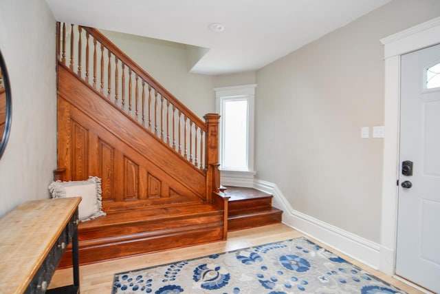 entrance foyer with stairs, baseboards, and wood finished floors