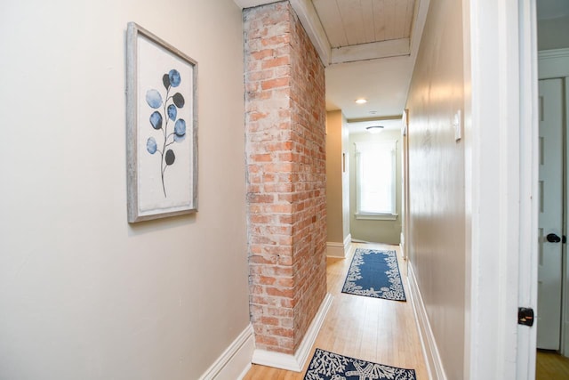 hall with attic access, baseboards, and wood finished floors