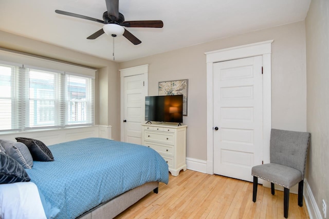 bedroom with light wood finished floors, baseboards, and a ceiling fan