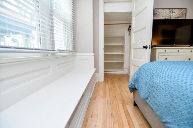 bedroom featuring light wood-style flooring and a spacious closet