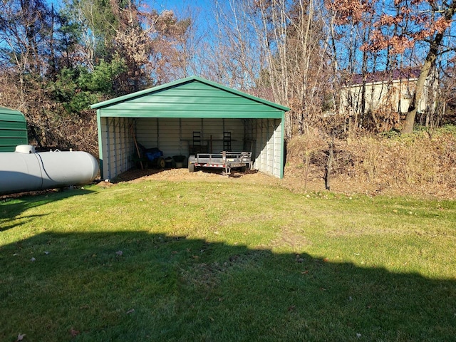 view of pole building with driveway, a carport, and a lawn