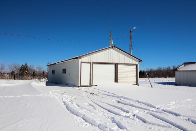 snow covered garage featuring a garage