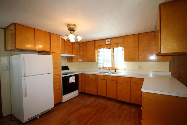 kitchen featuring light countertops, white appliances, brown cabinetry, and under cabinet range hood