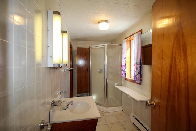 full bathroom with a baseboard radiator, a shower stall, tile walls, and tile patterned floors