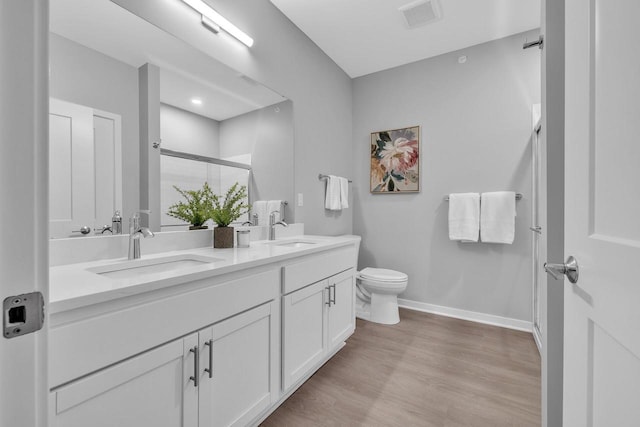 full bath with wood finished floors, a sink, toilet, and a shower stall