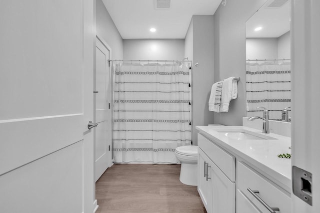 full bath featuring toilet, wood finished floors, vanity, visible vents, and a shower with curtain