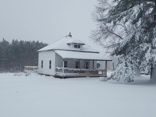 snow covered rear of property featuring a deck