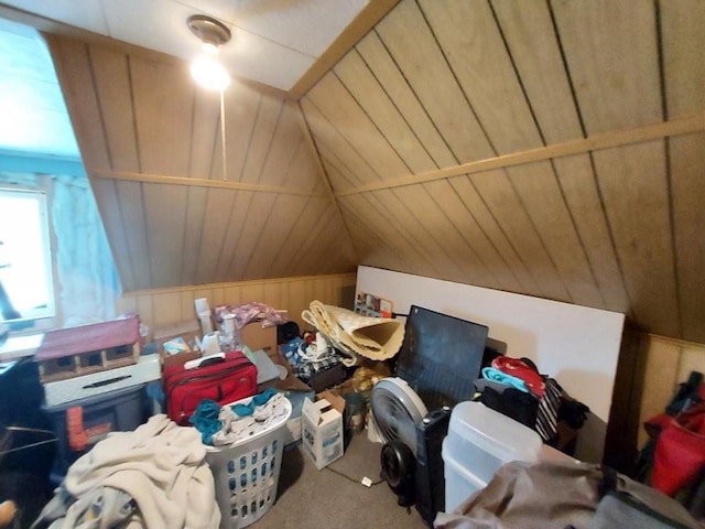 bonus room with vaulted ceiling, carpet, and wooden walls