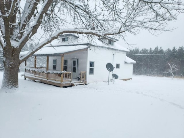 snow covered rear of property featuring a deck