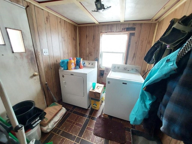 laundry area with laundry area, washer and clothes dryer, and wooden walls