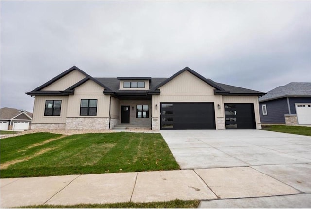 modern farmhouse style home with a garage, a front yard, stone siding, and driveway