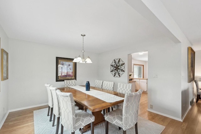 N2021 N Lake Shore Dr, Fontana, WI 53125 - dining area featuring a notable chandelier, light wood-type flooring, and baseboards