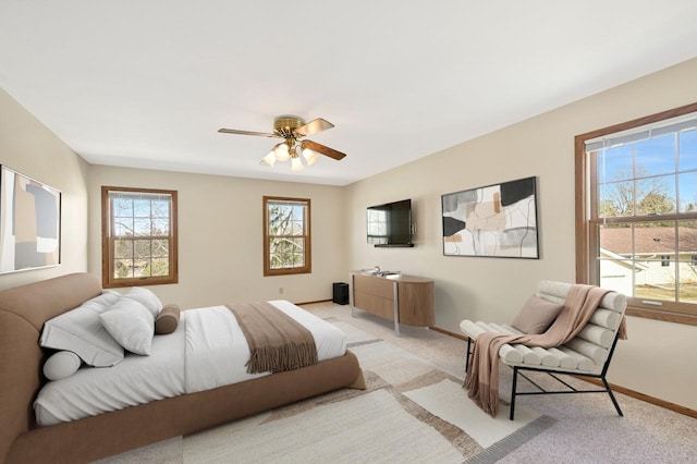 bedroom featuring light carpet, ceiling fan, and baseboards