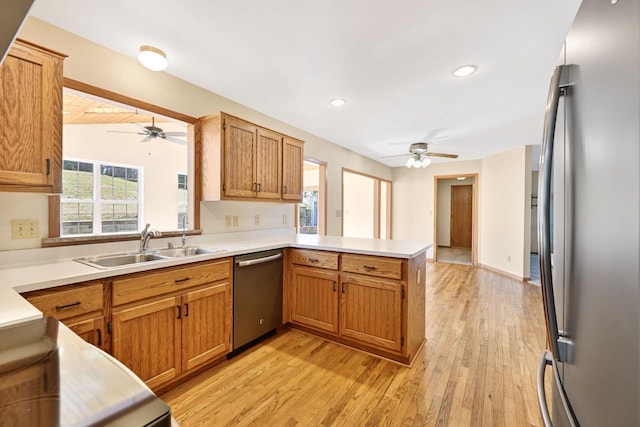 kitchen with ceiling fan, a peninsula, a sink, and stainless steel appliances