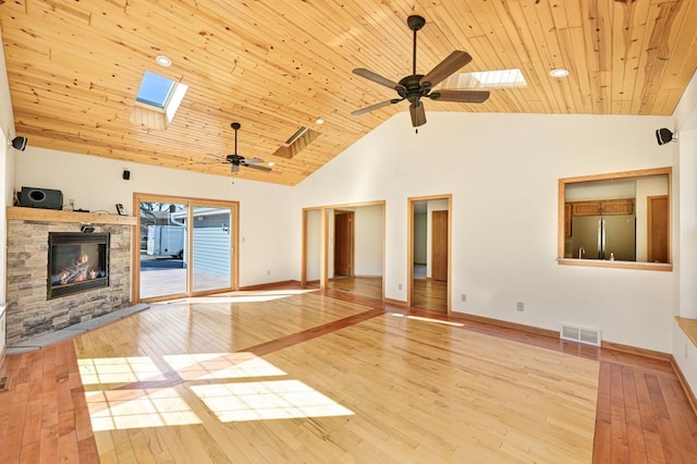 unfurnished living room featuring visible vents, a skylight, a ceiling fan, and wood-type flooring