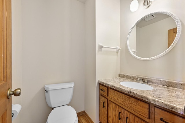 half bathroom with toilet and vanity