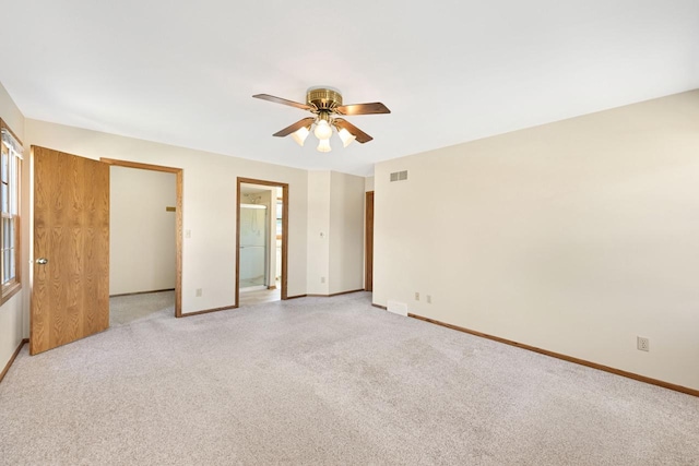 unfurnished bedroom with visible vents, light carpet, ensuite bath, baseboards, and ceiling fan