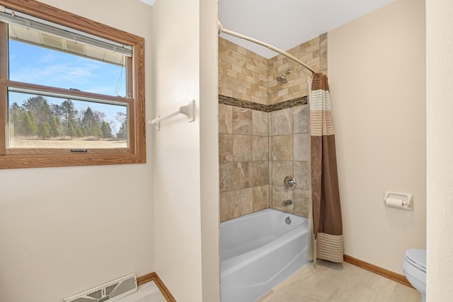 bathroom with shower / bath combination with curtain, toilet, baseboards, and visible vents