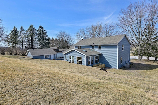 back of property featuring central AC unit and a lawn