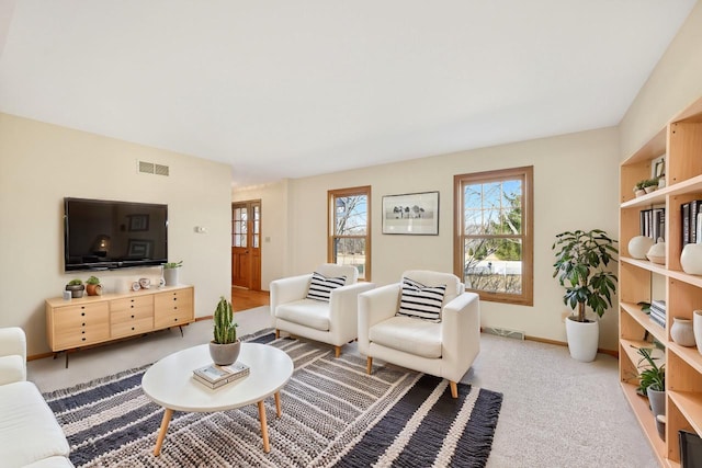 living area featuring light carpet, visible vents, and baseboards