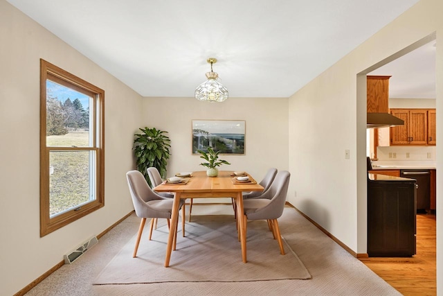 dining room featuring visible vents, light wood-type flooring, and baseboards