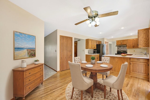 dining room with light wood finished floors, recessed lighting, baseboards, and ceiling fan