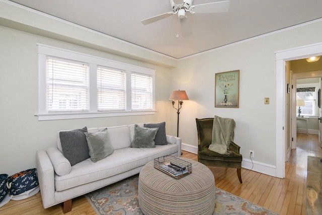 living room with baseboards, light wood-style floors, and a ceiling fan