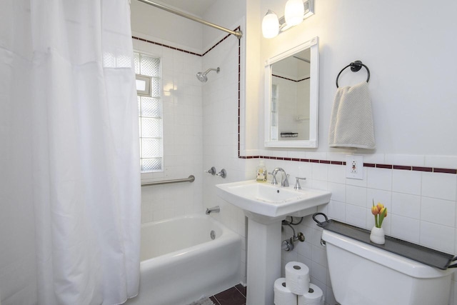 full bathroom featuring toilet, tile walls, and shower / tub combo