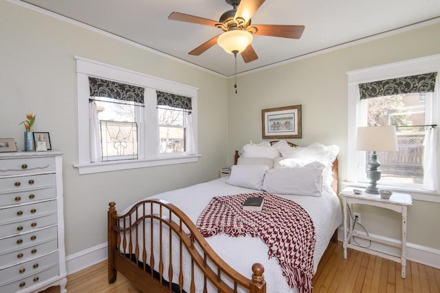 bedroom with ceiling fan, baseboards, light wood-style flooring, and ornamental molding